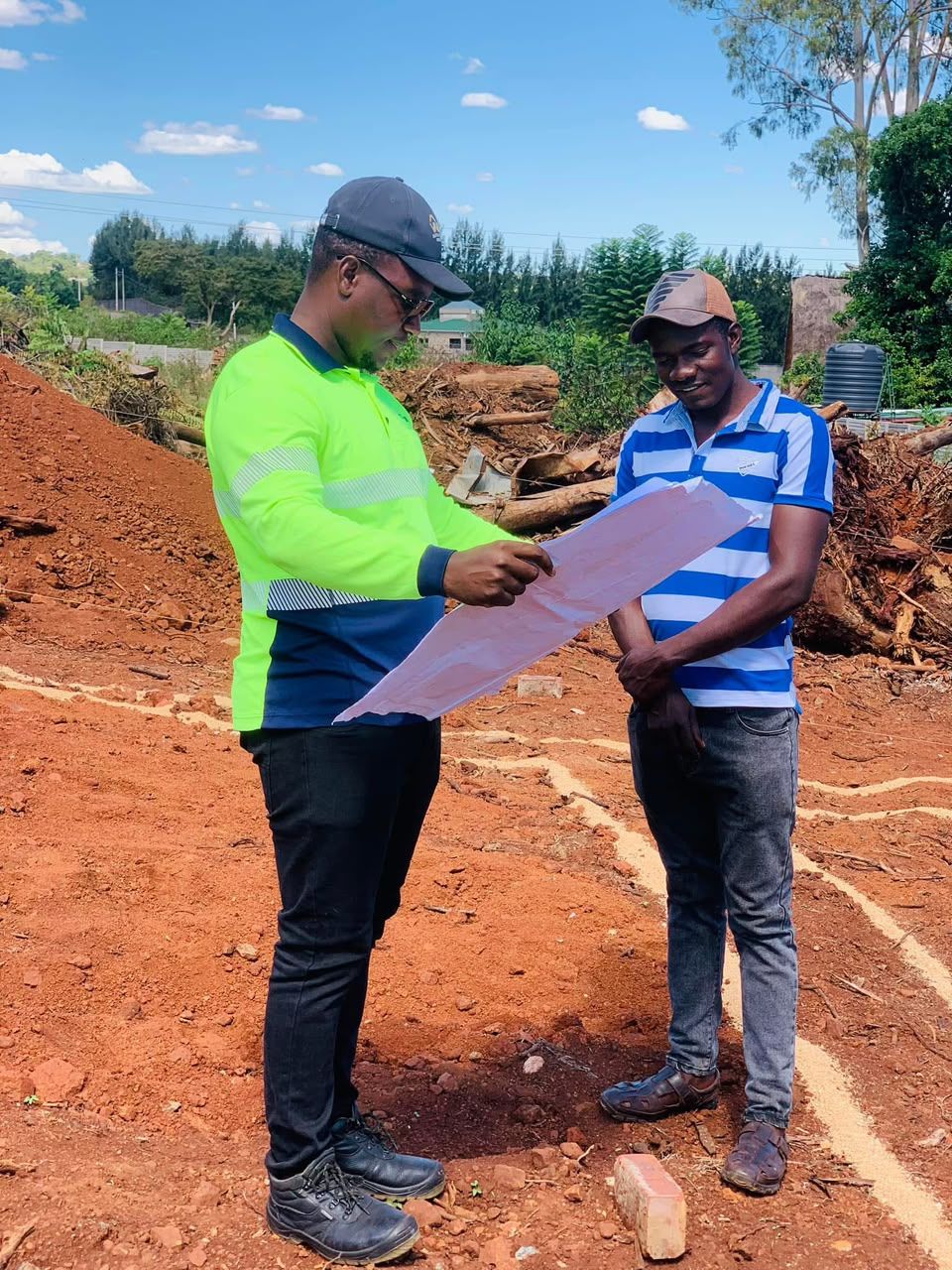 Vakanesu engineer reviewing drawings with a client on site